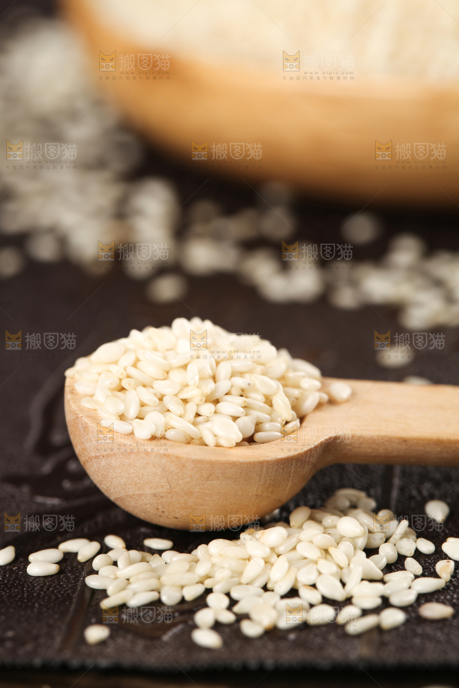 黑底上勺子里挖着脱皮白芝麻