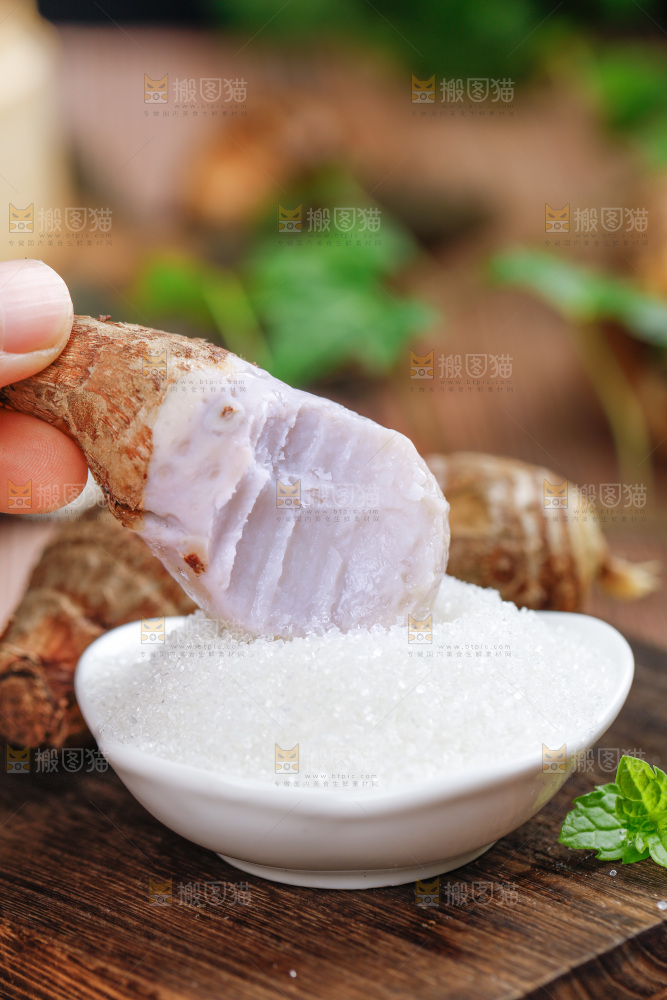 手上拿着一个沾糖的小芋头