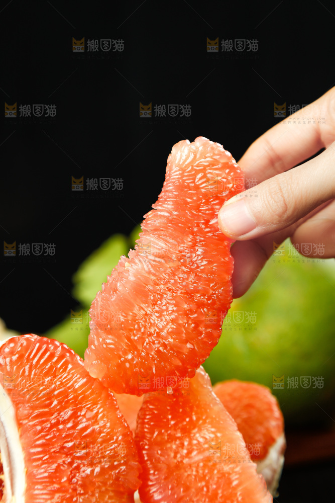 手上拿着红心柚果肉