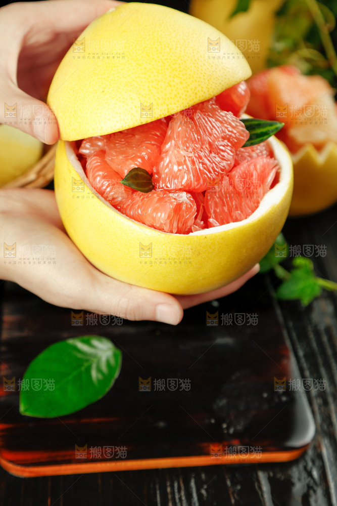 手上拿着红肉蜜柚