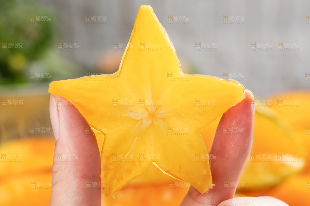 手上拿着一块五角星杨桃