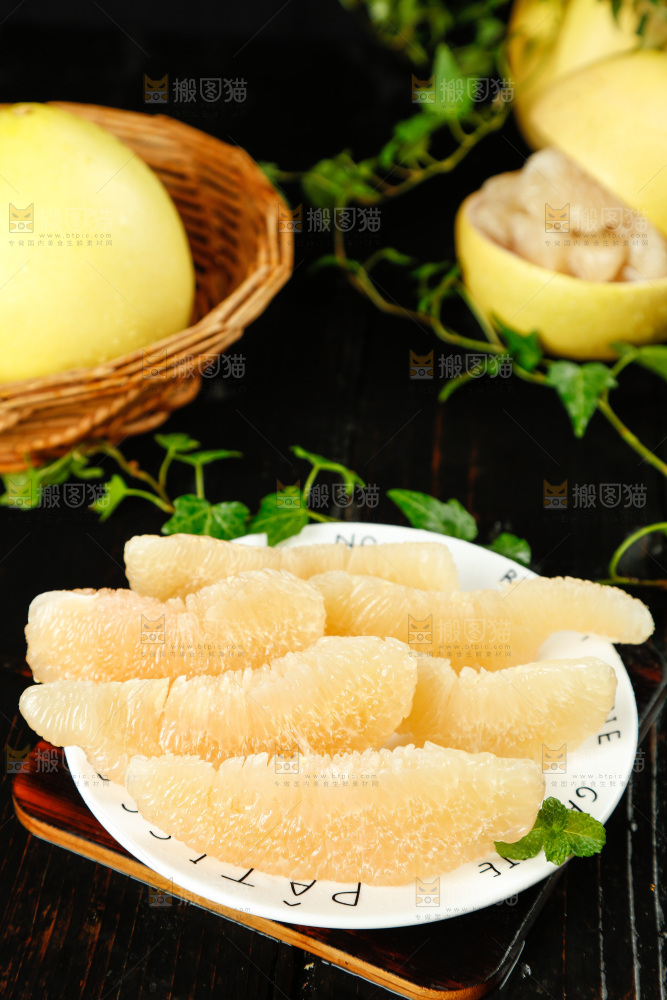黑底上放着一盘白心蜜柚