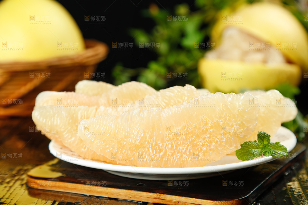 黑底上放着一盘白心蜜柚