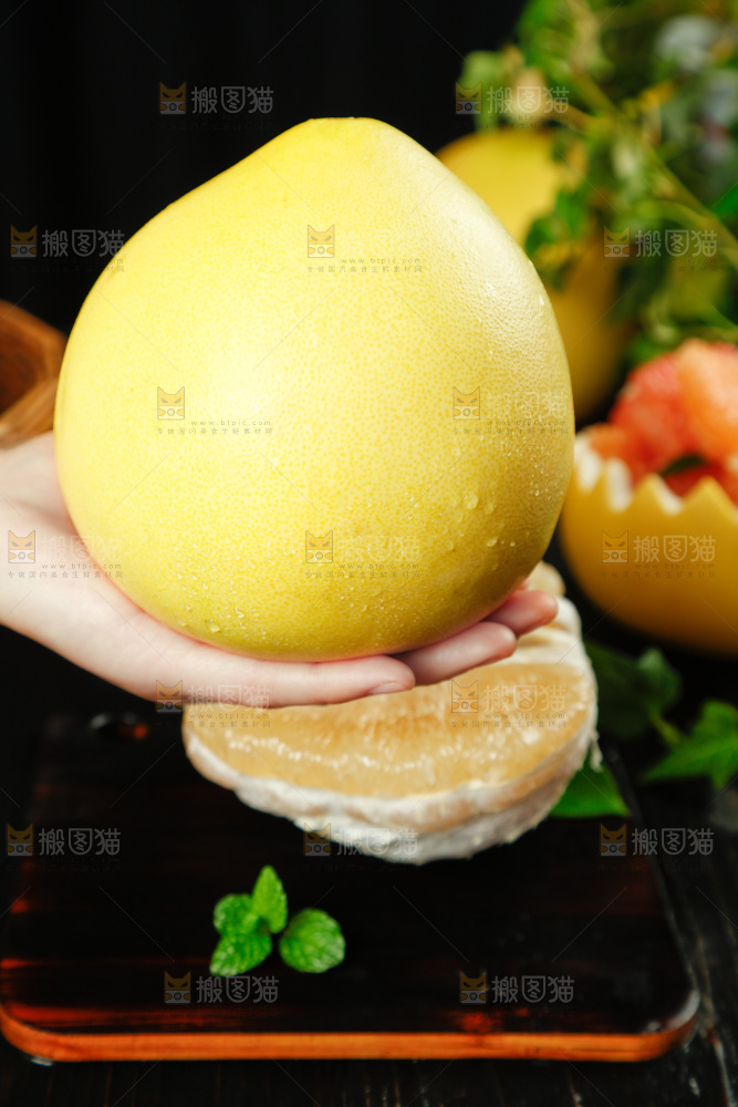 手上拿着蜜柚