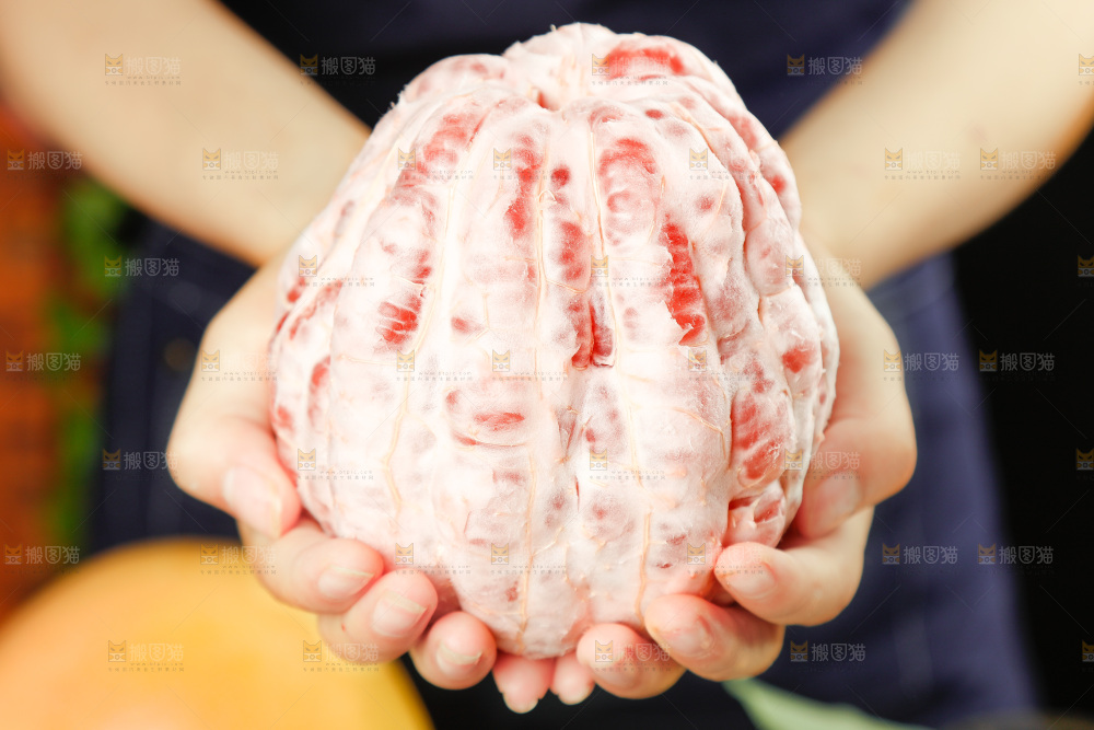 手里捧着剥皮的红心柚子