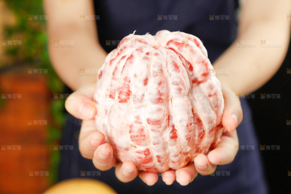 手里捧着剥皮的红心柚子