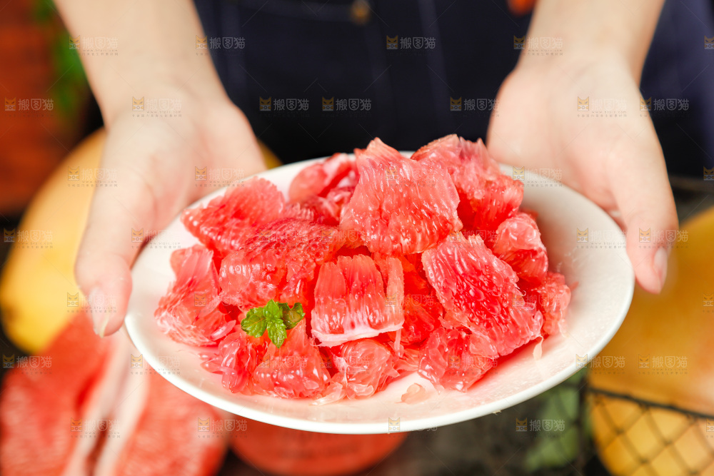 手里捧着剥皮的红心柚子
