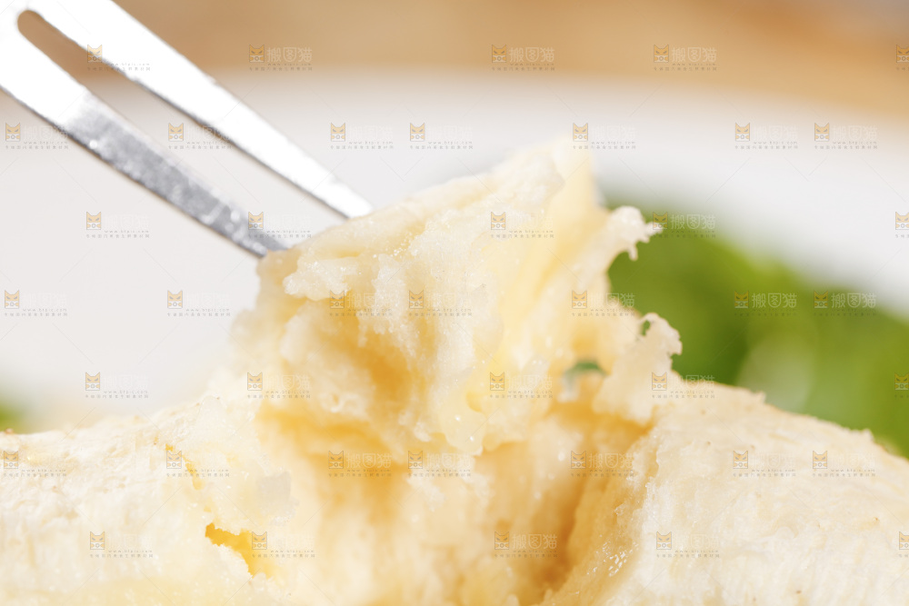 浅底上叉子叉着一块红皮香蕉果肉