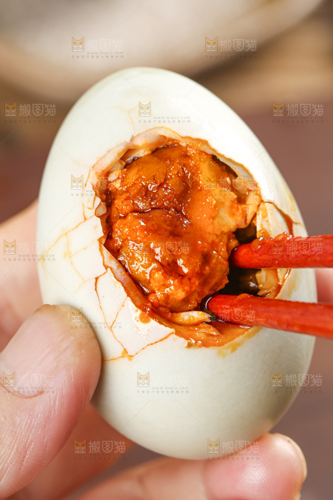 浅底上手拿着流油的咸鸭蛋