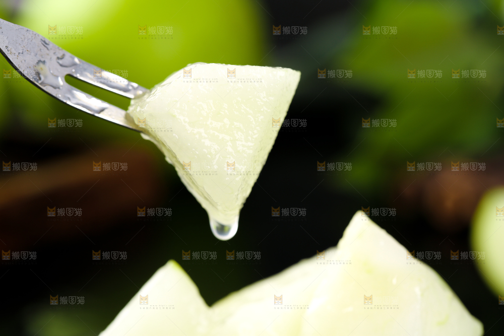 黑底叉子叉着一块削皮的苹果梨果肉