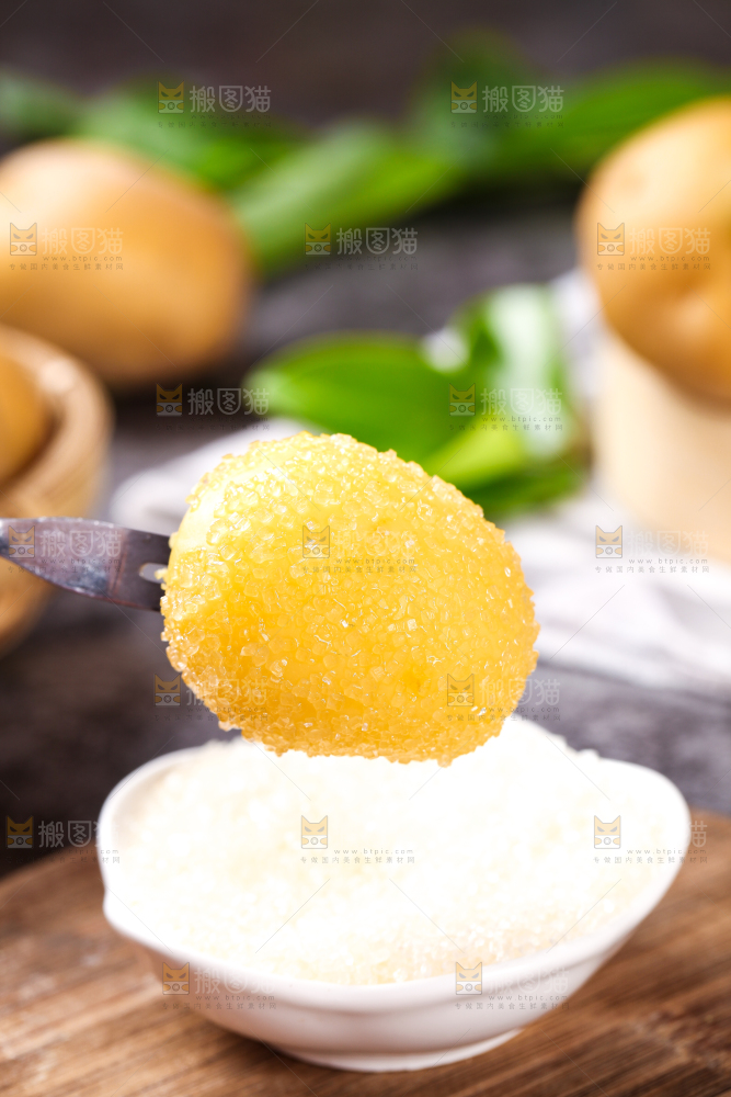 叉子叉着蘸糖的黄心熟土豆