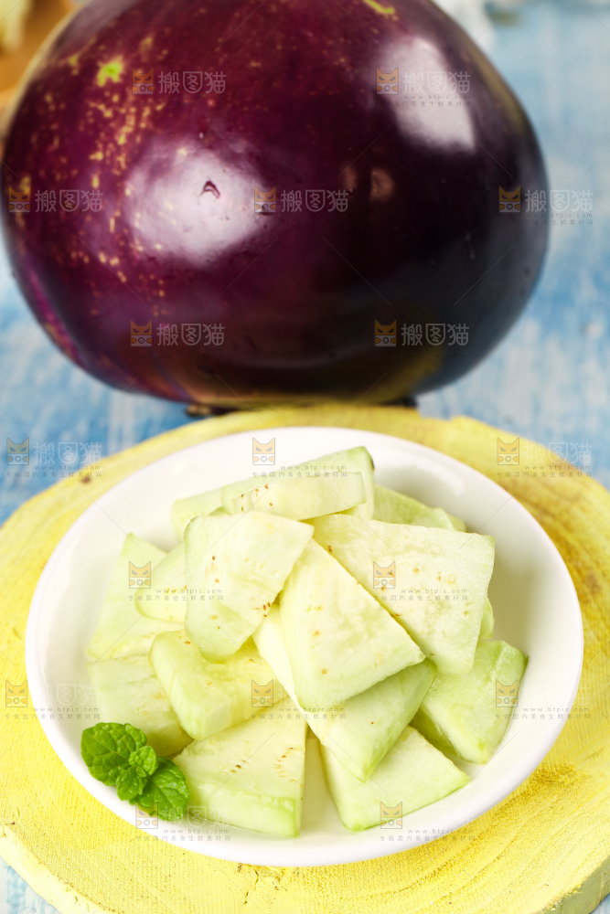 木板上放着一碟削皮的茄子