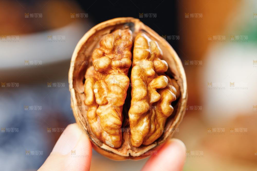 手拿剥开的纸皮核桃