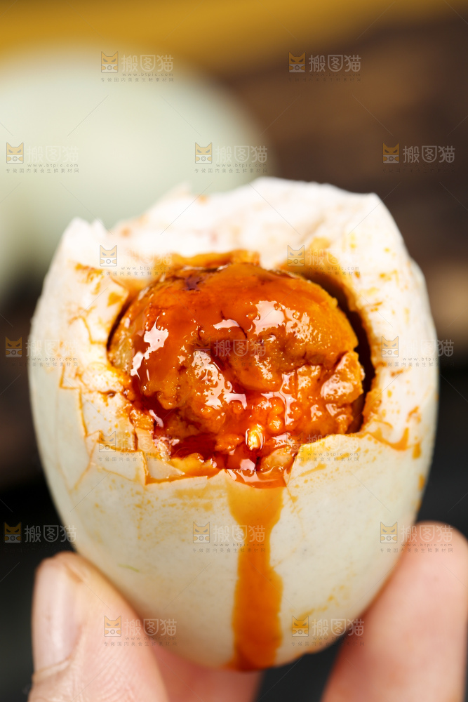 黑底上手拿着高邮咸鸭蛋