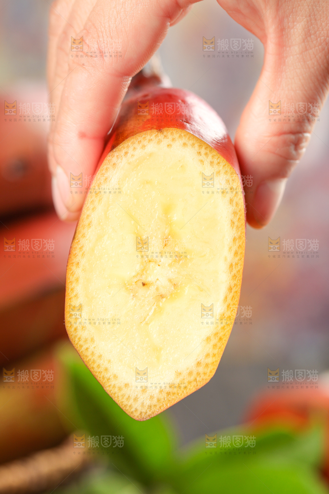 浅底上手拿着一块红皮香蕉