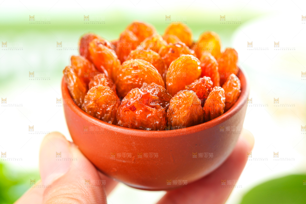 浅底上手拿一碟玫瑰红葡萄干