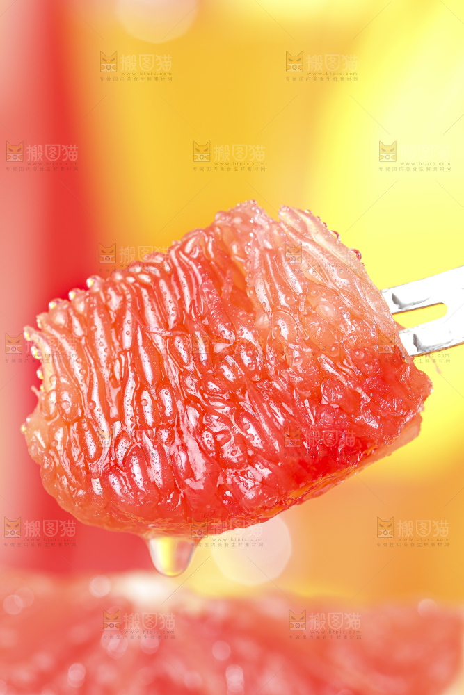 叉子叉着剥皮的红心西柚果肉