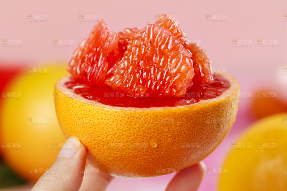 手拿剥皮的红心西柚果肉