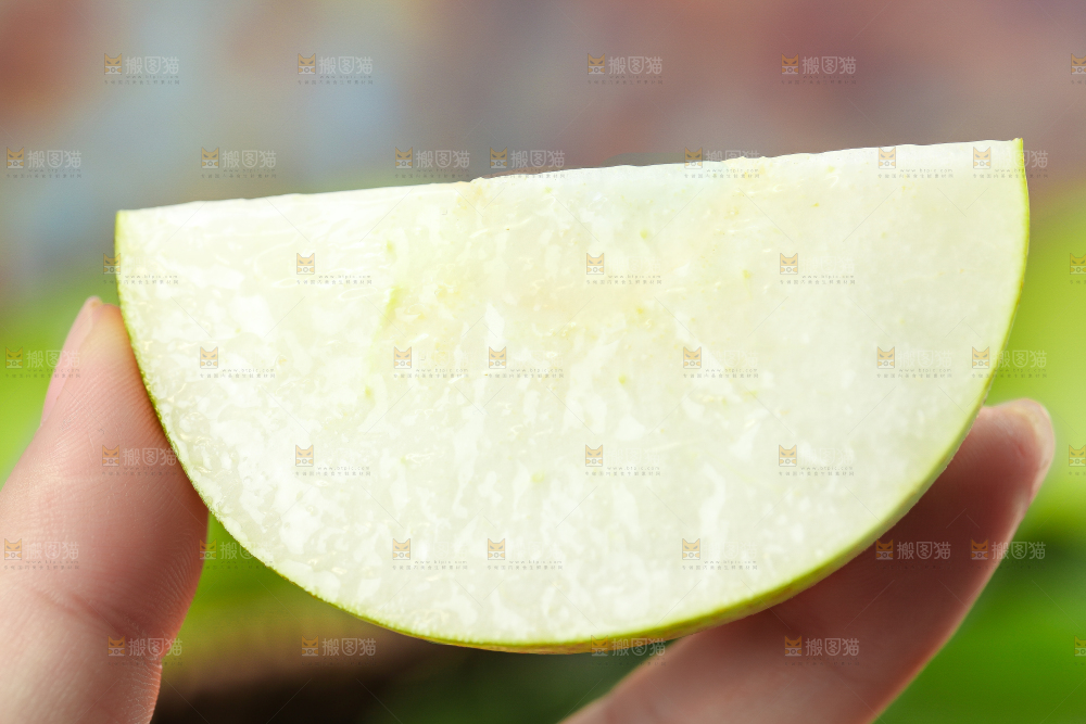 木底上手拿一块的苹果梨