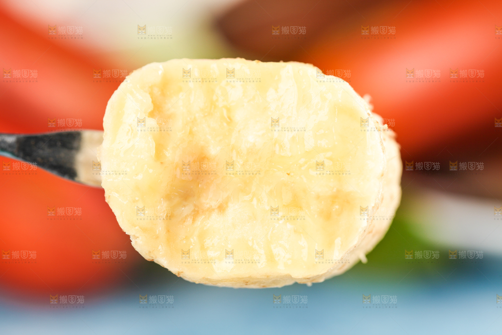 浅底上叉子叉着一块红皮美人蕉果肉