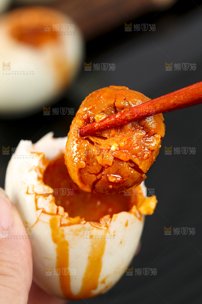 黑底上筷子夹着红心咸鸭蛋黄