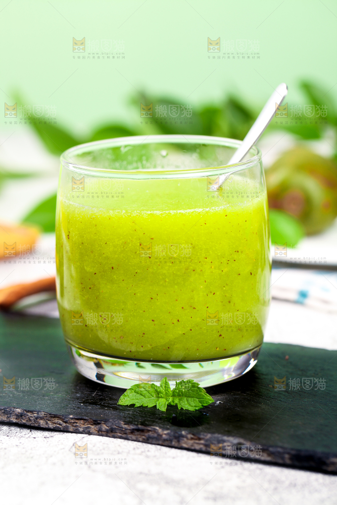 黑石板上放着一杯猕猴桃果汁