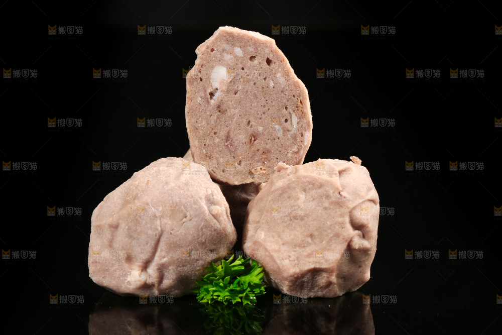 切开的牛肉丸放在黑底上