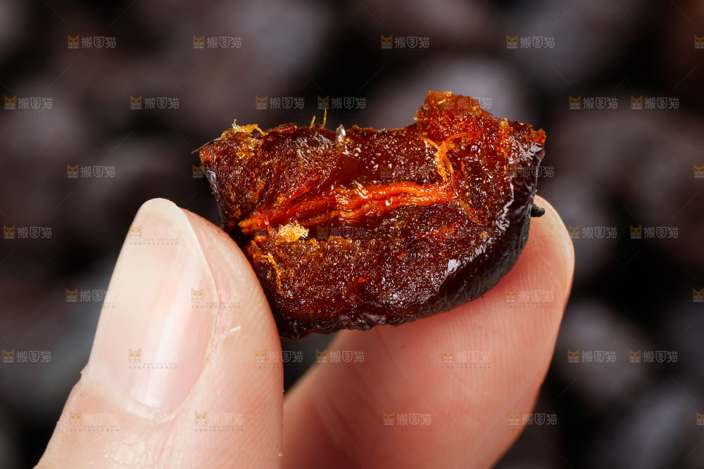 手拿掰开的黑枣