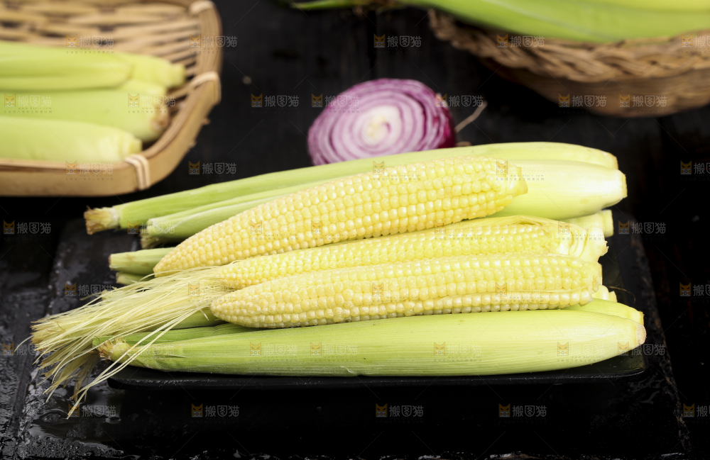 黑石板上放着水果玉米笋