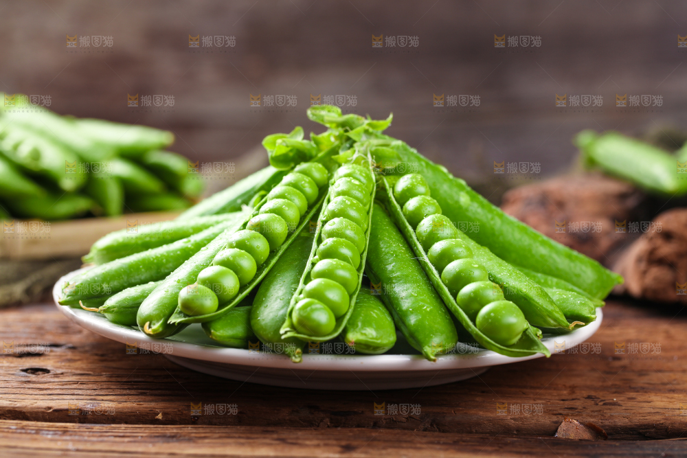 木底上放着一盘新鲜豌豆