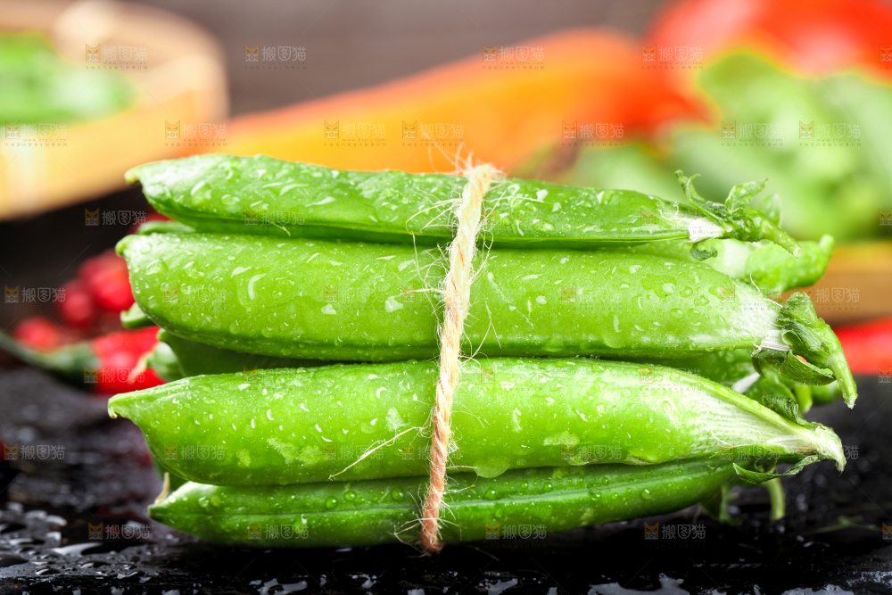 黑底上放着一捆新鲜豌豆荚