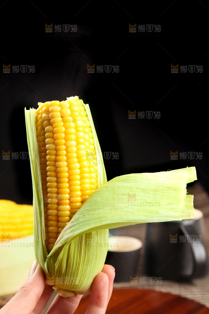 手里拿着新鲜玉米