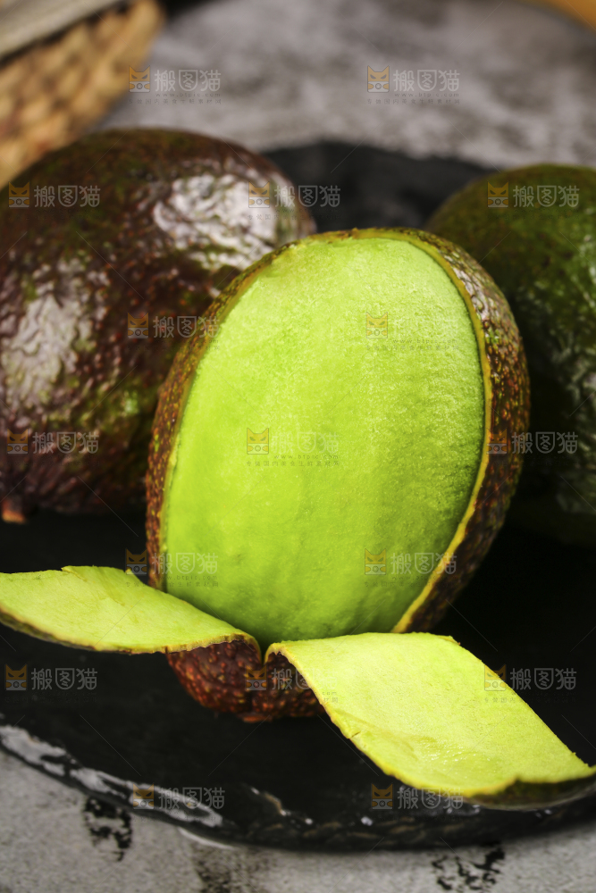 黑石板上放着削皮的墨西哥牛油果