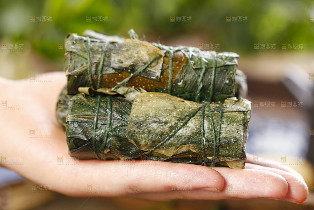 手里拿着竹筒糯米饭