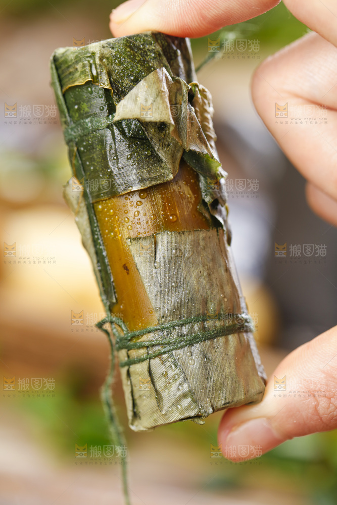 手里拿着竹筒糯米饭