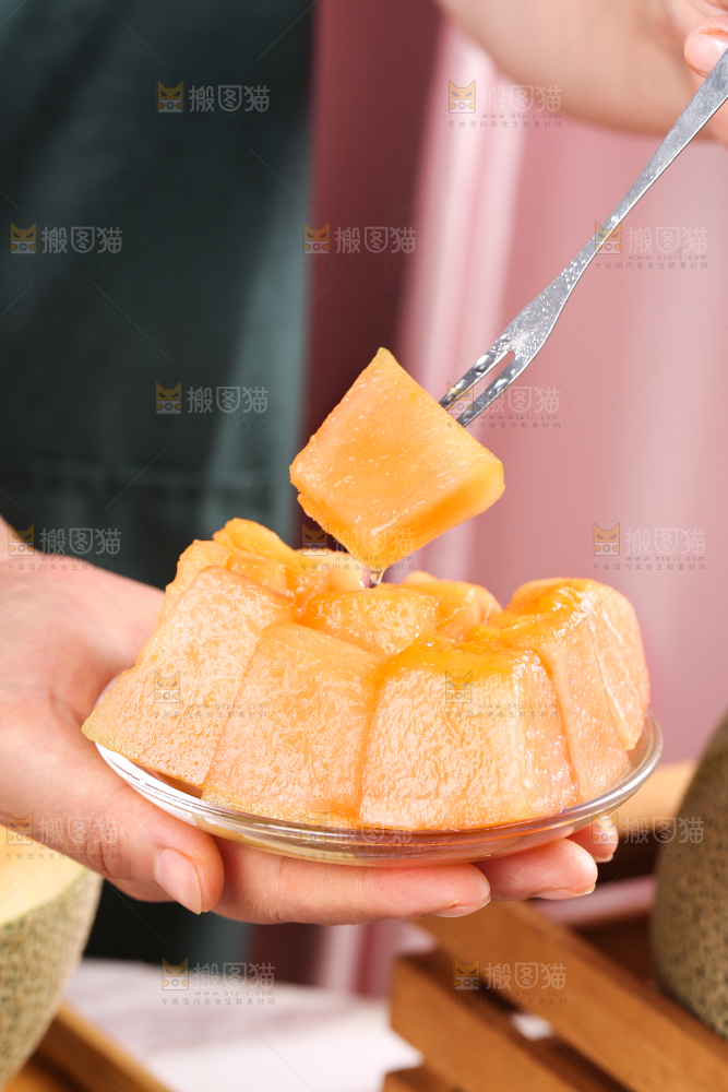 手里端着一碟切块的哈密瓜
