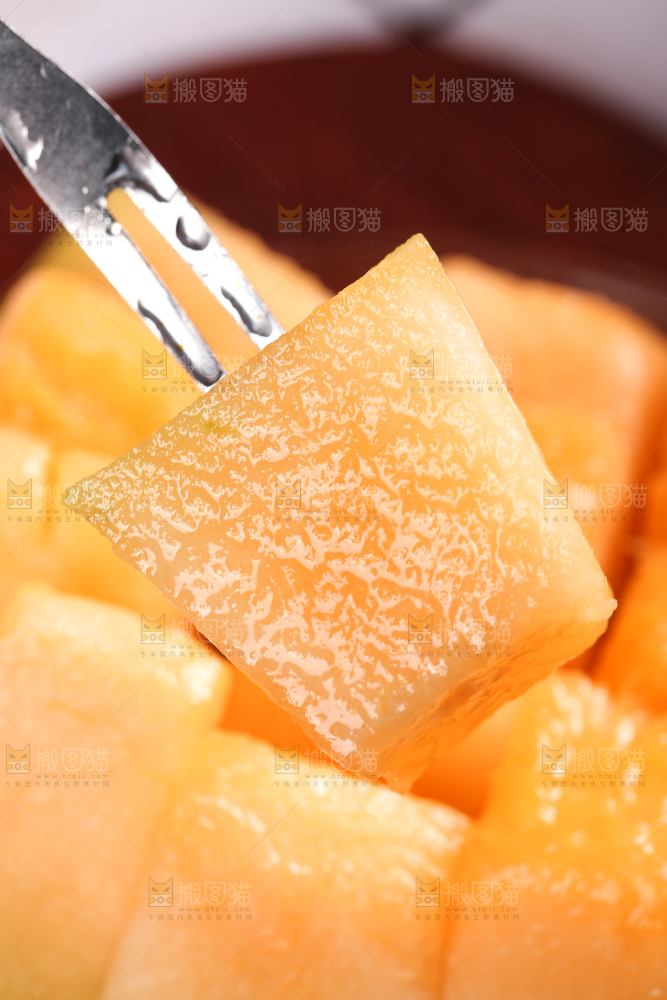 叉子叉着一块新鲜哈密瓜