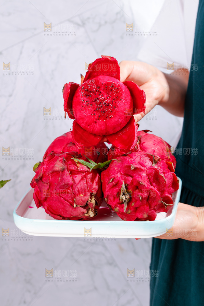 手里拿着一碟红心火龙果
