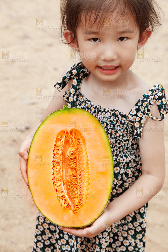 小女孩手里拿着哈密瓜