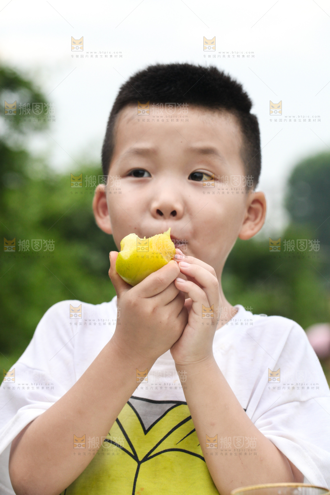 小男孩正在吃李子
