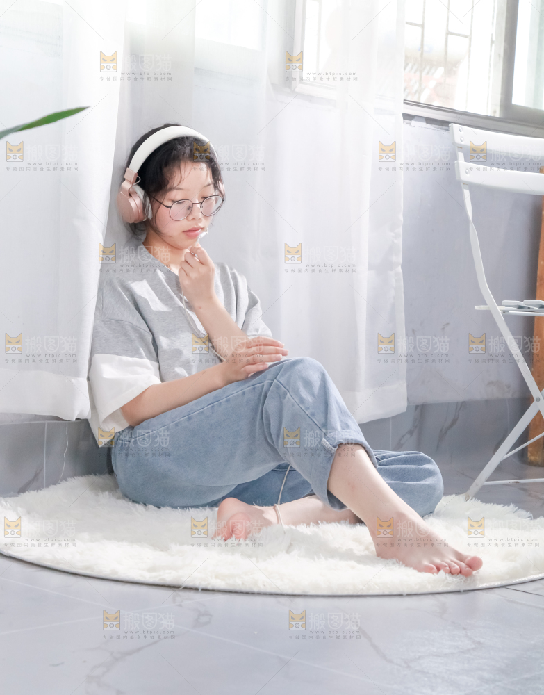 毛毯上坐着一位带耳机的女孩