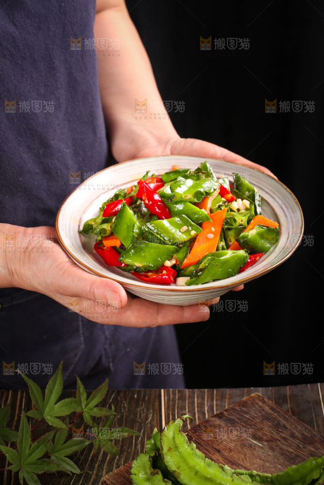 手里拿着一盘炒四角豆