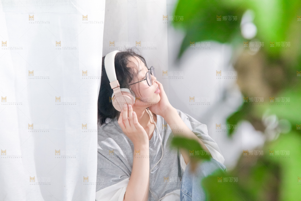 毛毯上坐着一位带耳机的女孩