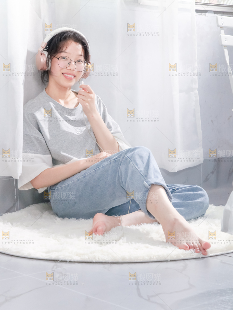 毛毯上坐着一位带耳机的女孩