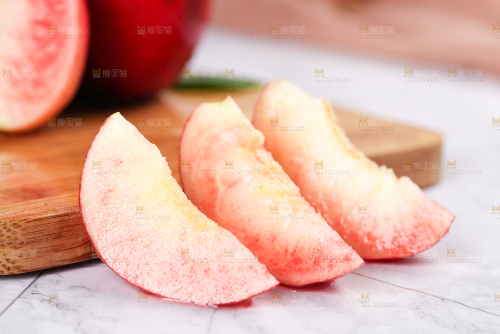 木板上摆放着红心桃子