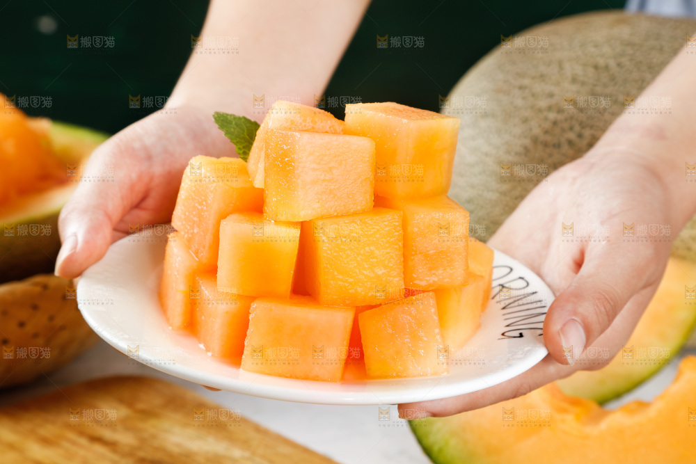 手里拿着一碟切块的哈密瓜