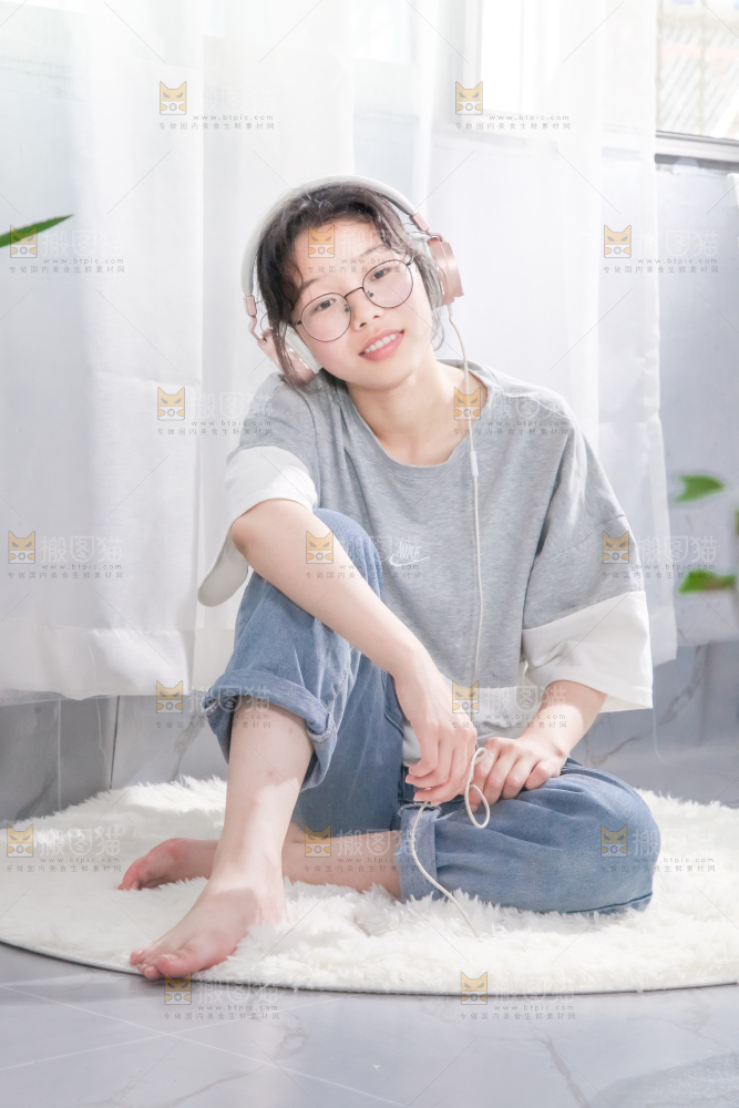 毛毯上坐着一位带耳机的女孩
