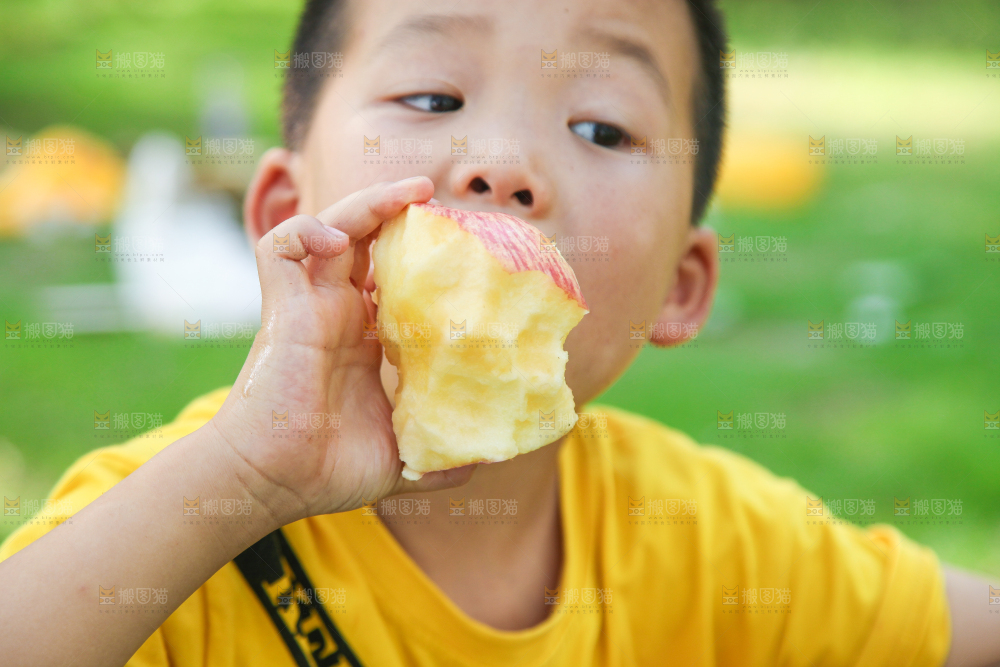 小男孩正在吃苹果