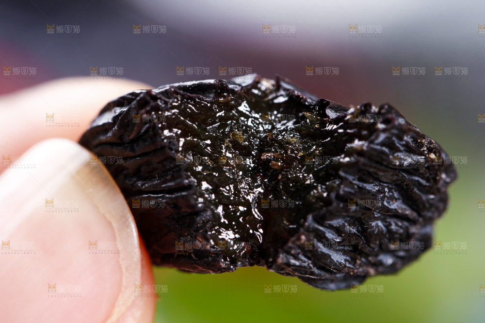 手里拿着黑葡萄干