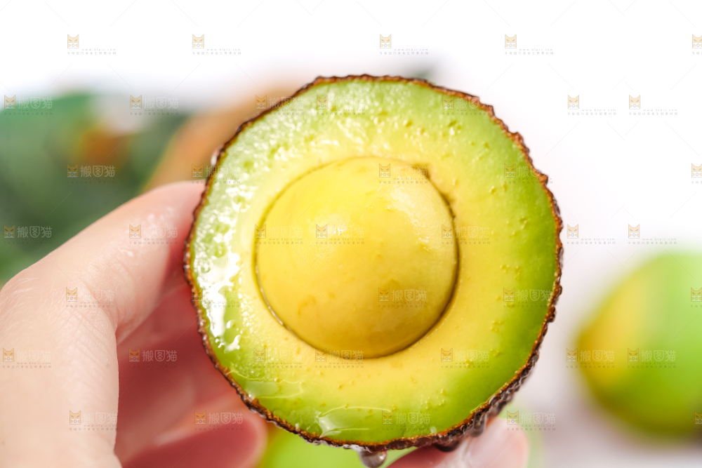 手里拿着新鲜牛油果